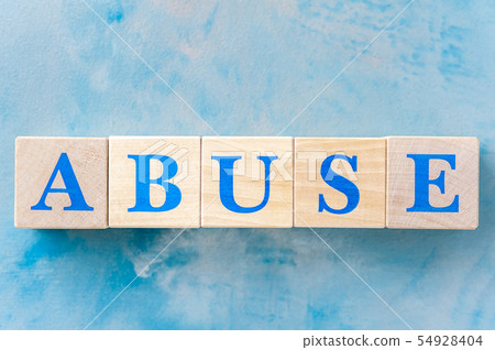 Wooden cubes with word ABUSE on blue table. 54928404