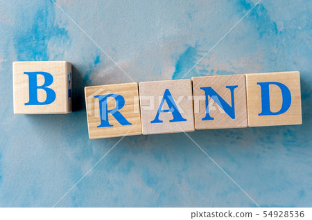 Wooden cubes with word BRAND on blue table. 54928536