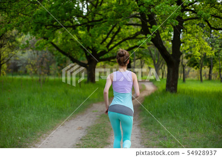 Sports brunette girl jogging in the park. Green Sports brunette girl jogging in the park. Green 54928937