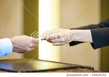 Receptionist giving a key to guest Receptionist giving a key to guest 54929192