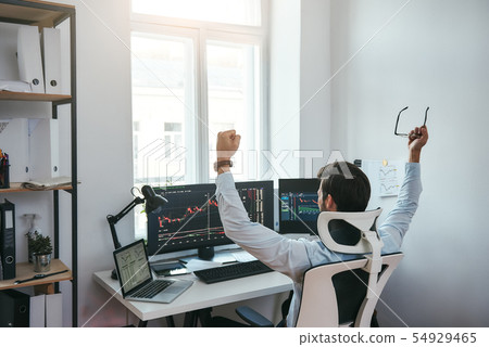 Winner Back view of stock trader with raised hands holding eyeglasses and feeling happy while Winner Back view of stock trader with raised hands holding eyeglasses and feeling happy while 54929465