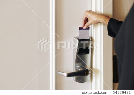 Woman opening the door with cardkey Woman opening the door with cardkey 54929481