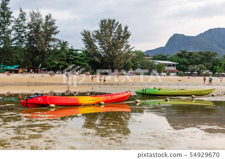 A two colorful kayaks sat on the sandy bottom of 54929670