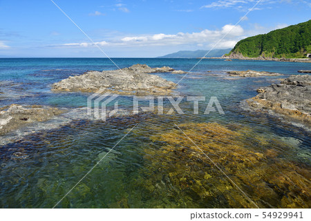 Taking a picture of the summer landscape of the blue sea and reefs on Nagare Beach, Taisei-ku, Hokkaido 54929941