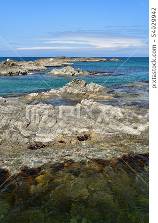 Taking a picture of the summer landscape of the blue sea and reefs on Nagare Beach, Taisei-ku, Hokkaido 54929942