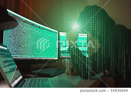 Cyber crime. Side view of young hacker in black hoodie using multiple computers and his smartphone 54930044