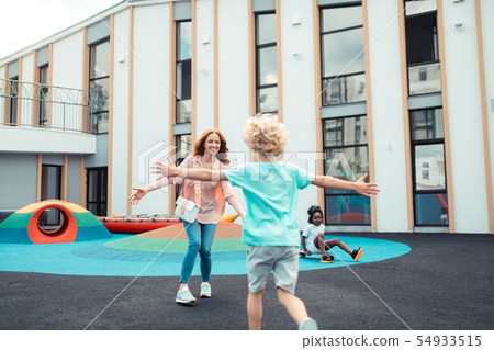Mother and son running to meet each other. Mother and son running to meet each other. 54933515
