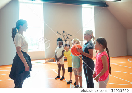 School children playing ball with their sports teacher. School children playing ball with their sports teacher. 54933790
