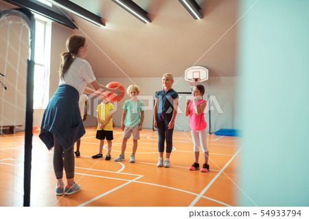 Coach teaching her pupils how to play ball. Coach teaching her pupils how to play ball. 54933794