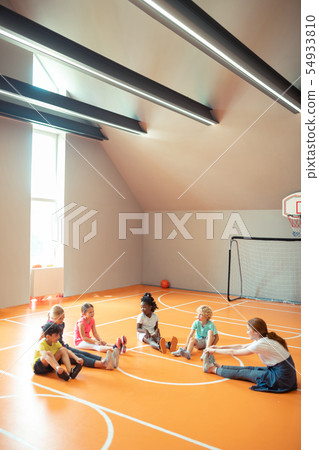Young coach training her pupils in spacious gym. Young coach training her pupils in spacious gym. 54933810