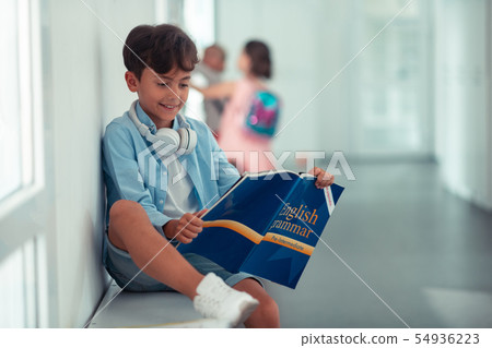 Boy repeating English grammar while reading book 54936223