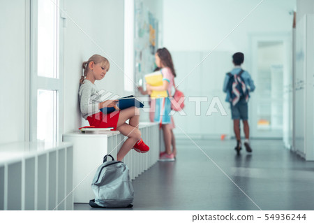 Schoolgirl sitting on the window sill and repeating information Schoolgirl sitting on the window sill and repeating information 54936244