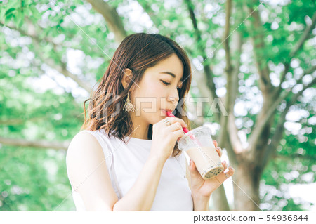 Woman drinking tapioca milk tea 54936844