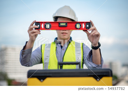 Worker man holding red aluminium spirit level tool Worker man holding red aluminium spirit level tool 54937782