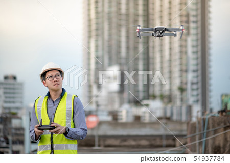 Asian engineer flying drone over construction site Asian engineer flying drone over construction site 54937784