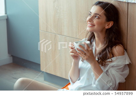 Woman feeling excited while drinking coffee in the morning 54937899