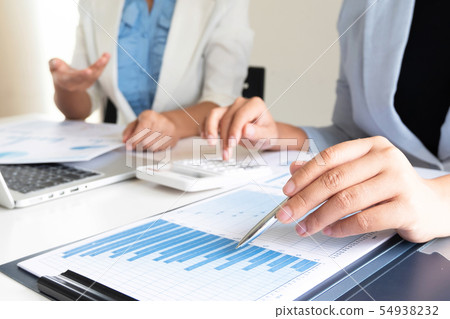 Two business leader women discussing the charts. Two business leader women discussing the charts. 54938232