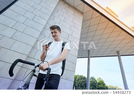 Handsome hipster man posing with bicycle in the city. 54938273