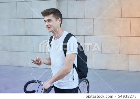 Handsome hipster man posing with bicycle in the city. 54938275