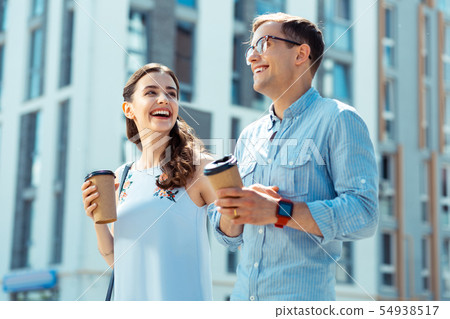 Husband wearing smart watch laughing with wife while walking Husband wearing smart watch laughing with wife while walking 54938517