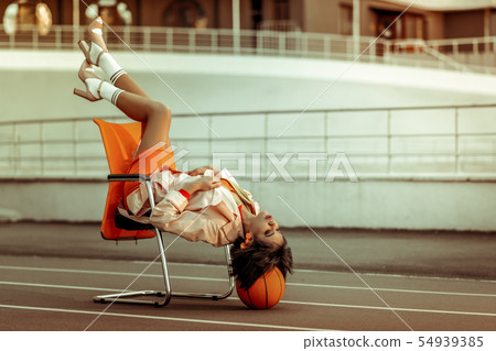 Attractive brunette girl sitting in unusual pose 54939385