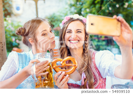 Best friends in Bavarian Tracht making a Selfie with the phone Best friends in Bavarian Tracht making a Selfie with the phone 54939510