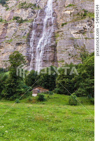 Waterfall and small house in Jungfrau valley  54940344