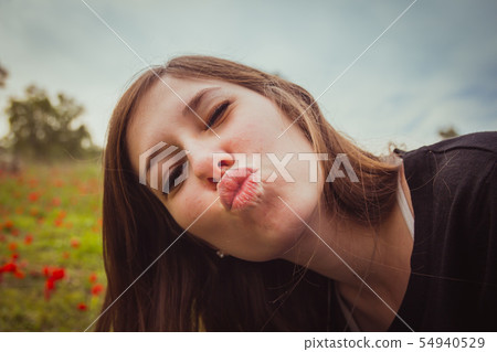 Young woman making duckface kiss Young woman making duckface kiss 54940529