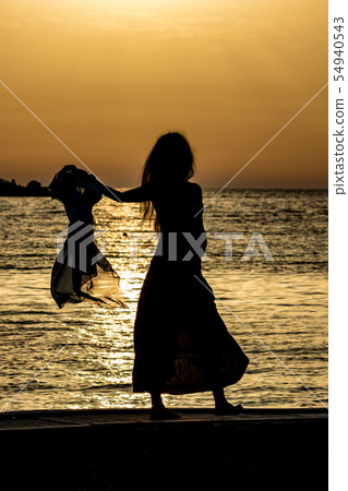 Beautiful silhouette at sunset golden sea water Beautiful silhouette at sunset golden sea water 54940543
