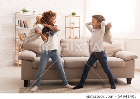 African-american girls having fun, fighting with pillows 54941403