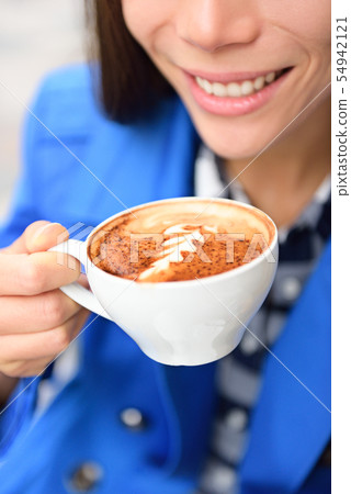 Latte art coffee cup hand closeup - woman drinking 54942121