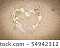 Shells on the ocean beach, heart shape background Shells on the ocean beach, heart shape background 54942312