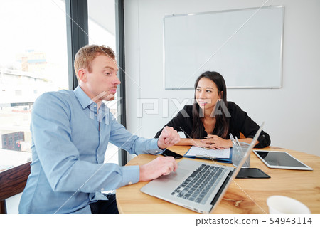 Business colleagues working over business plan Business colleagues working over business plan 54943114