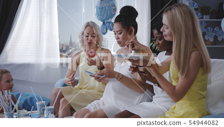Friends eating dessert while celebrating young mother Friends eating dessert while celebrating young mother 54944082