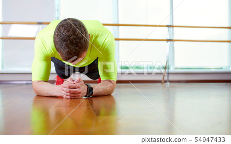 Plank it Confident muscled young man wearing sport wear and doing plank position while exercising on Plank it Confident muscled young man wearing sport wear and doing plank position while exercising on 54947433