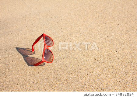 Red sunglasses on the beach 54952054