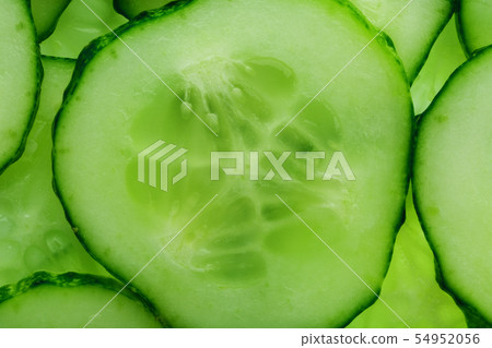 Slices of green fresh cucumber backlit as a 54952056
