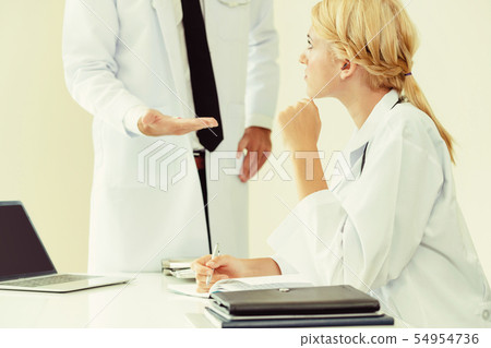 Female doctor at hospital talking to her partner. 54954736