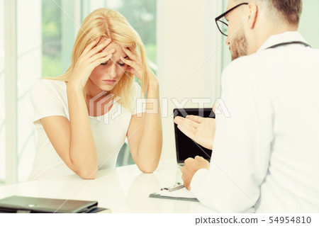 Male Doctor and Female Patient in Hospital Office 54954810
