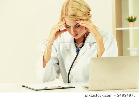 Serious doctor working in hospital office. 54954973