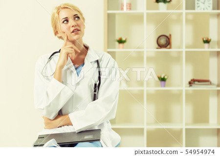Young female doctor working in hospital office. 54954974