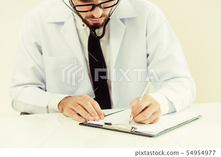 Doctor in hospital writing on a paper document. Doctor in hospital writing on a paper document. 54954977