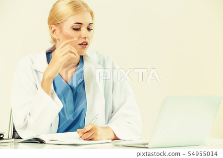 Doctor in hospital working on medical report. Doctor in hospital working on medical report. 54955014