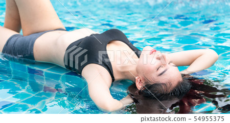 Woman at swimming pool in summer in luxury resort. 54955375