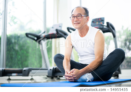 Senior man do body stretching in fitness center. Senior man do body stretching in fitness center. 54955435
