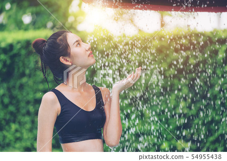 Woman taking shower at swimming pool in resort. Woman taking shower at swimming pool in resort. 54955438