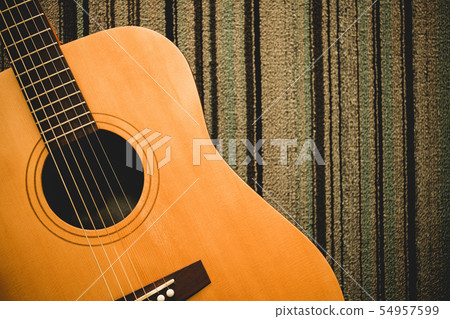 Vintage tone photo of Acoustic guitar on carpet Vintage tone photo of Acoustic guitar on carpet 54957599