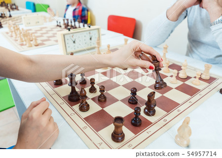 Woman making a chess move playing against a man Woman making a chess move playing against a man 54957714