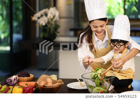 Mother and son help to make vegetable salad Mother and son help to make vegetable salad 54959123