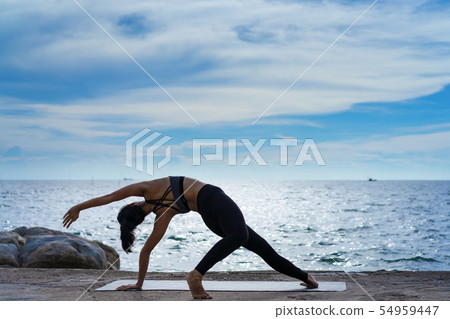 Portrait of young woman practicing yoga at the sea Portrait of young woman practicing yoga at the sea 54959447